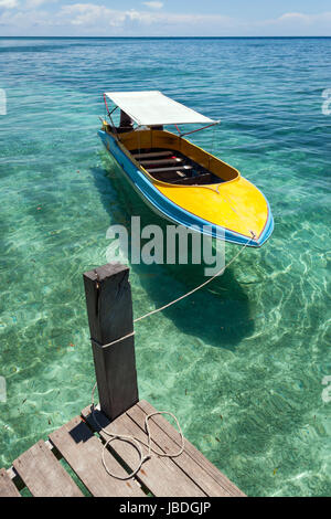 Insel Sipadan, Borneo, Malaysia - Bunte Boot schwimmend in ruhigem, kristallklarem Wasser. Stockfoto