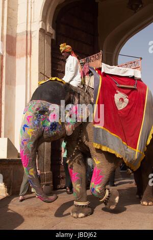 Mahut auf einem geschmückten Elefanten durch den Eingang des Amber Fort in Jaipur, Rajasthan, Indien. Stockfoto