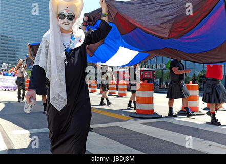 Eine Schwester of Perpetual Indulgence hilft eine große Version der Leather Pride Flag in der Innenstadt von Cleveland, Ohio, USA während einer LGBT Pride März tragen. Stockfoto