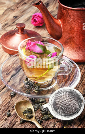 Kupferkessel, Teerose Knospen und Tasse Kräutertee Stockfoto