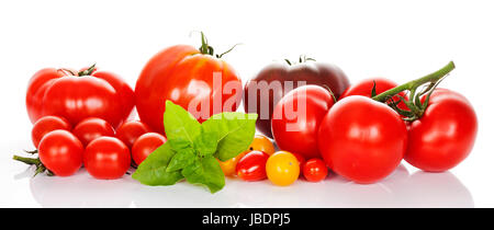 frische Tomaten mit grünen Blättern, die isoliert auf weißem Hintergrund Stockfoto