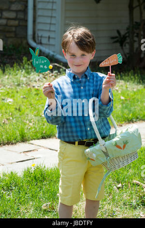 Young Boy draußen gekleidet, für Ostern Korb halten Stockfoto