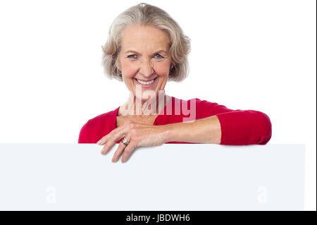 Lächelnde Frau in Casuals hinter Plakat im Alter von Stockfoto