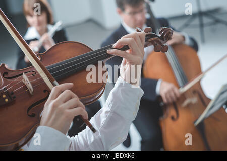 Klassik-Sinfonieorchester Streichersektion durchführen, Geigerin spielen im Vordergrund, Hände in der Nähe hoch Stockfoto