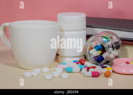 Bücher-Pillen. Medizin und Gesundheit Bücher auf einem Holztisch. Stockfoto