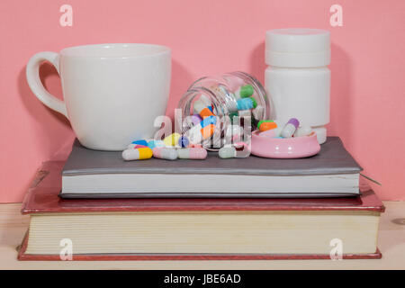 Bücher-Pillen. Medizin und Gesundheit Bücher auf einem Holztisch. Stockfoto