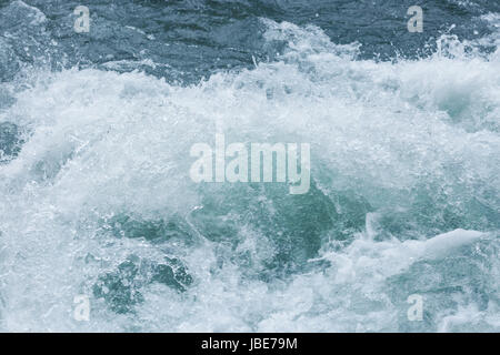 Spritzer von Berg Flusswellen hautnah. Am laufenden Band blauen Wassers im Ozean zeigt viele Turbulenzen und Spritzen. Stockfoto