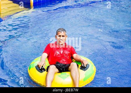 Happy 1 Indischen älterer Mann Entspannende aufblasbaren ring Resort Pool genießen Lächelnd Stockfoto