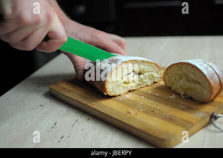 Mannhände schneiden Ananas Kuchen hautnah Stockfoto