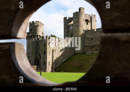 Barbican Zinnen, vorne, mit größer Torhaus / Torhaus im Hintergrund, durch Holzschäfte gesehen. Warwick Castle in Warwickshire, Großbritannien Stockfoto