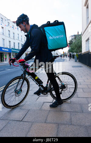 Deliveroo Speisen zum Mitnehmen Kurier Pedal Lieferzyklus / Push Fahrrad Radfahrer machen eine Lieferung laufen in Royal Leamington Spa. GROßBRITANNIEN (88) Stockfoto