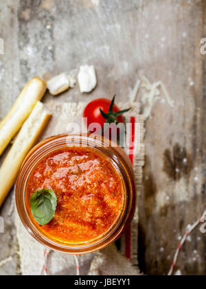 Draufsicht auf ein Glas heiße würzige Tomate lustvoll mit Grassini oder italienischen Brot-Sticks auf trashigen rustikalen hölzernen Hintergrund mit Exemplar Stockfoto