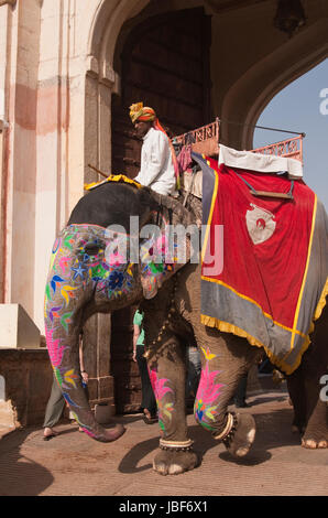 Mahut auf einem geschmückten Elefanten durch den Eingang des Amber Fort in Jaipur, Rajasthan, Indien. Stockfoto