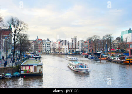 AMSTERDAM, Niederlande - 17. März 2014: Touristische Bootsfahrten am Kanal in Amsterdam. Fast 20 Prozent aller Kanal Kreuzfahrt Boote sind jetzt elektrisch angetrieben. Stockfoto