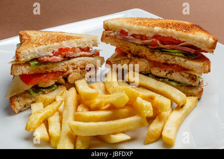 Clubsandwich mit Huhn auf einem weißen Teller Stockfoto