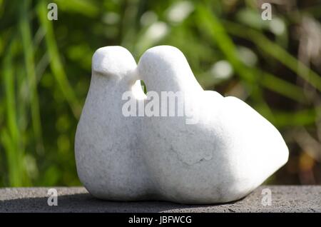 Vogelpaar aus weissen Stein Sitzt Auf Einem Natursteinsockel paar Vögel aus weißem Stein sitzt auf einem natürlichen Steinsockel Stockfoto