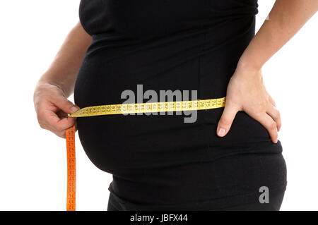 Schwangere Frau, die ihre Taille messen Stockfoto