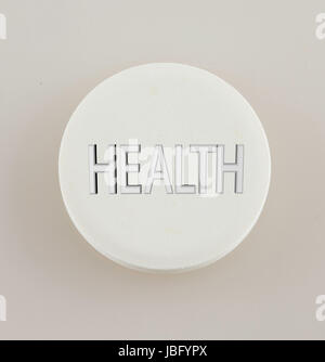 Weiße Pille mit Text "Gesundheit" auf der oberen, grauen Hintergrund Stockfoto