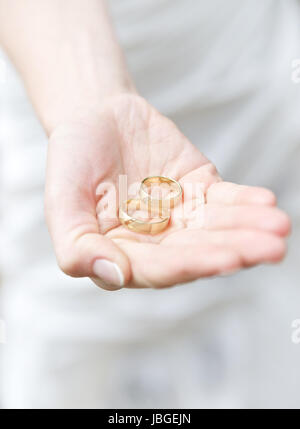 Trauringe in der Hand der Braut Stockfoto
