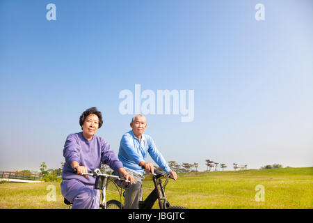 asiatische Senioren paar Radfahren im park