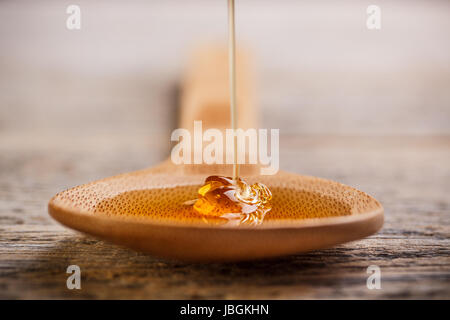 Kochlöffel mit wildem Honig hinein fallen Stockfoto