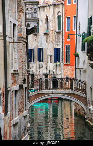 Häuser entlang der schmalen Kanal, verbunden durch eine steinerne Brücke in Venedig, Italien. Venedig befindet sich in einer Gruppe von 117 kleine Inseln, die durch c getrennt sind Stockfoto