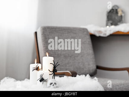 Graue Polsterstuhl in Halloween Ambiente mit Kerzen Stockfoto