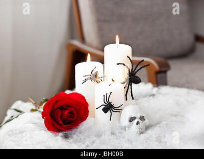 Graue Polsterstuhl in Halloween Ambiente mit Kerzen Stockfoto