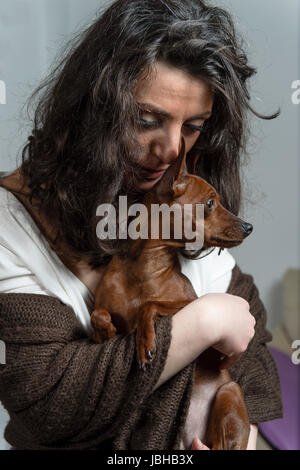 Frau hält ihren Hund Stockfoto