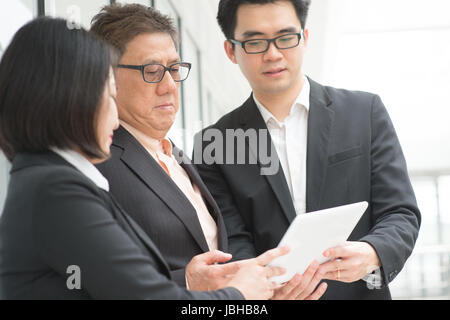 Asien-Geschäft-Team-Meeting. Personal erklärt und zeigt Bericht auf Digitalrechner Tablet zu CEO Chef Büro. Stockfoto