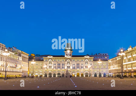Das Rathaus, der Palazzo del Municipio, ist das dominierende Gebäude auf Triester Haupt Platz Piazza Dell Unita d Italia. Triest, Italien, Europa. Quadratische beleuchtete Stadt erschossen in der Abenddämmerung. Stockfoto