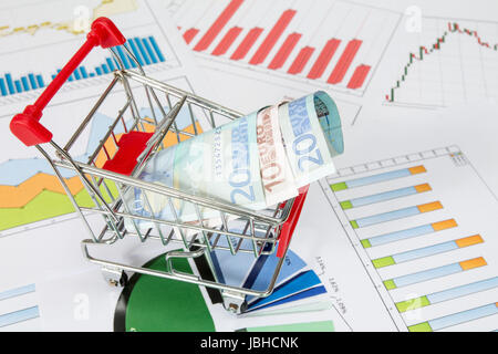 Warenkorb mit Geld auf die Diagramme Stockfoto