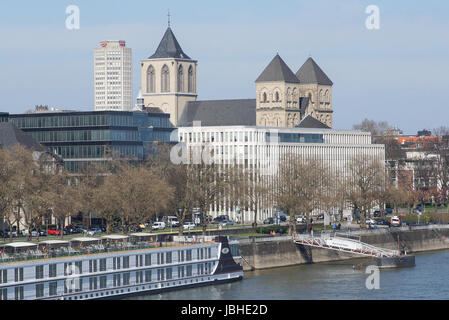 Köln, Deutschland - 23. März 2017: Kontrast - alte Kirche St. Kunibert unter modernen Bürogebäuden am 23. März 2017 in Köln, Deutschland Stockfoto