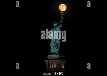 New York, USA. 10. Juni 2017.  Genannt der Erdbeere Mond Vollmond ist neben der Freiheitsstatue in New York am Samstag gesehen. Foto: Vanessa Carvalho / Brasilien Foto Presse/Alamy Live-Nachrichten Stockfoto