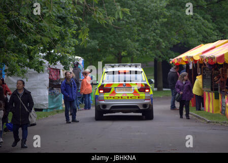 Glasgow, Schottland. 11. Juni. Die beiden Elemente der in diesem Jahre britische Sommer waren anwesend, als Regen auf die West End Festival Big Sunday im Kelvingrove Park strömte. Besucher wurden stark durch die Polizei und private Sicherheitsdienste überwacht. Bewaffnete Polizei patrouilliert Parks im Fahrzeuginneren während Taschen durch private Sicherheitspersonal an den Eingängen durchsucht wurden.  Polizisten patrouillierten Veranstaltungsort zu Fuß oder Fahrrad.  Kredit Gerard Fähre/Alamy Live-Nachrichten Stockfoto