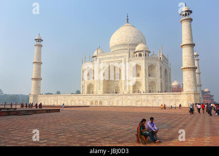 Touristen sitzen auf einer Bank am Taj Mahal Komplex, Agra, Uttar Pradesh, Indien. Taj Mahal wurde 1632 von den Mughal Kaiser Shah Jahan, h beauftragt.