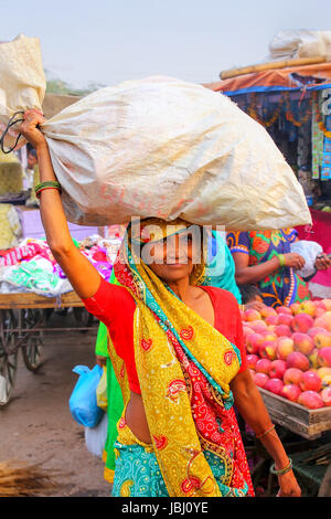 Frau Sack auf dem Kopf auf Kinari Basar in Agra, Uttar Pradesh, Indien. Agra ist eine der bevölkerungsreichsten Städte in Uttar Pradesh Stockfoto