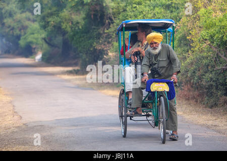 Besucher fahren Fahrrad Rikscha im Keoladeo Ghana Nationalpark in Bharatpur, Rajasthan, Indien. Der Park wurde im Jahr 1971 eine geschützte Oase erklärt und Stockfoto