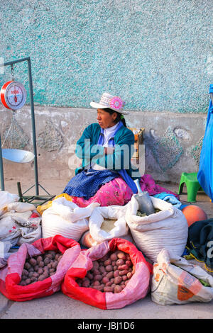 Frau verkauft Kartoffeln und Getreide auf dem Straßenmarkt in Chivay Stadt, Peru. Chivay Stadt ist die Hauptstadt der Provinz Caylloma. Stockfoto