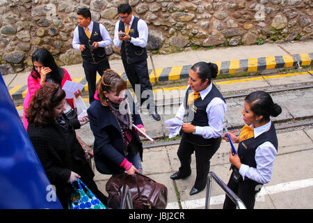 Ausländische Passagiere Perurail Touristenzug nach Machu Picchu am Bahnhof in Ollantaytambo in Peru. PeruRail transportiert die überwiegende Mehrheit Stockfoto