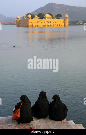 Muslimische Frauen sitzen am Ufer des Mannes Sagar See in Jaipur, Rajasthan, Indien. Stockfoto