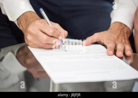 Manager-Gesang-Dokument auf Glasschreibtisch im Büro Stockfoto