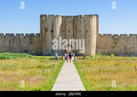 Touristen betreten die Altstadt durch eines der wichtigsten mittelalterlichen Gateways von Aigues Mortes, Nimes, Gard, Occitanie, Frankreich Stockfoto