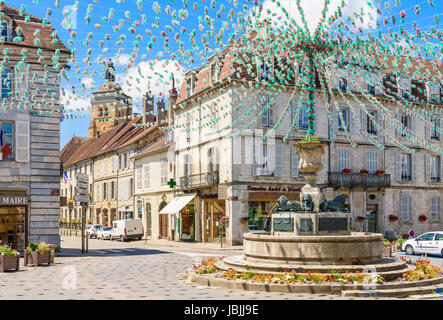 Springbrunnen und die umliegenden Gebäude in Place De La Liberté, geschmückt für eine Fête, Arbois, Jura, Frankreich Stockfoto