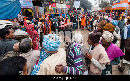 BABUGHAT, KOLKATA, WESTBENGALEN / Indien 12. Januar 2014: Hindu Anhänger Qued für Lebensmittel in Wintermorgen am Babughat Durchgangslager, Kalkutta. Die Anhänger sind auf dem Weg zur Heiligen Stätte Gangasagar (Sagar). Stockfoto