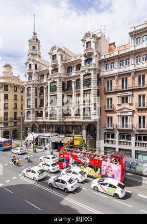 Madrids großen Gebäuden und Madrid City Tour Bus entlang Calle Gran Via, Madrid, Spanien Stockfoto