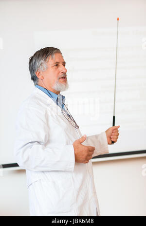 Senior Chemieprofessor geben einen Vortrag vor Klassenzimmer voller Studenten (flachen DOF; getönten Farbbild) Stockfoto