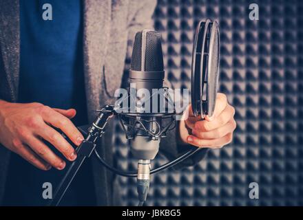 Männliche Stimmtalent im Studio Audio Recording-Equipment für die nächste Session vorbereiten. Stockfoto