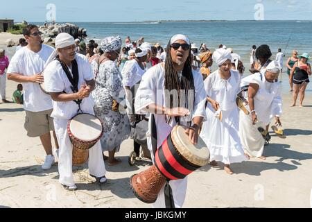 Nachkommen von versklavten Afrikanern nach Charleston in den mittleren Durchgang brachte halten eine Prozession zu Ehren ihre Angehörigen verloren, während eine Gedenkveranstaltung am Fort Moultie National Monument 10. Juni 2017 in Sullivans Island, South Carolina. Die Middle Passage bezieht sich auf den Dreieckshandel in dem Millionen von Afrikanern als Teil des Atlantischen Sklavenhandels in die neue Welt verschifft wurden. Schätzungsweise 15 % der Afrikaner starben in den Prozess der Erfassung und den Transport auf See und erheblich mehr. Die Zahl der afrikanischen Todesfälle zurückzuführen, die Middle Passage-Reise wird auf 2 Millionen geschätzt. Stockfoto