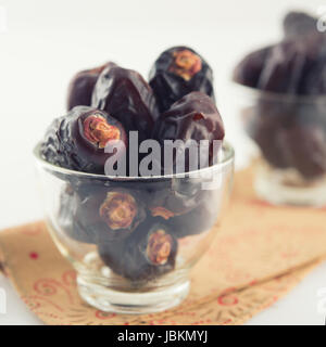 Frucht stammt. Haufen von getrockneten Datum Obst im Glas auf einfarbigen Hintergrund. Stockfoto